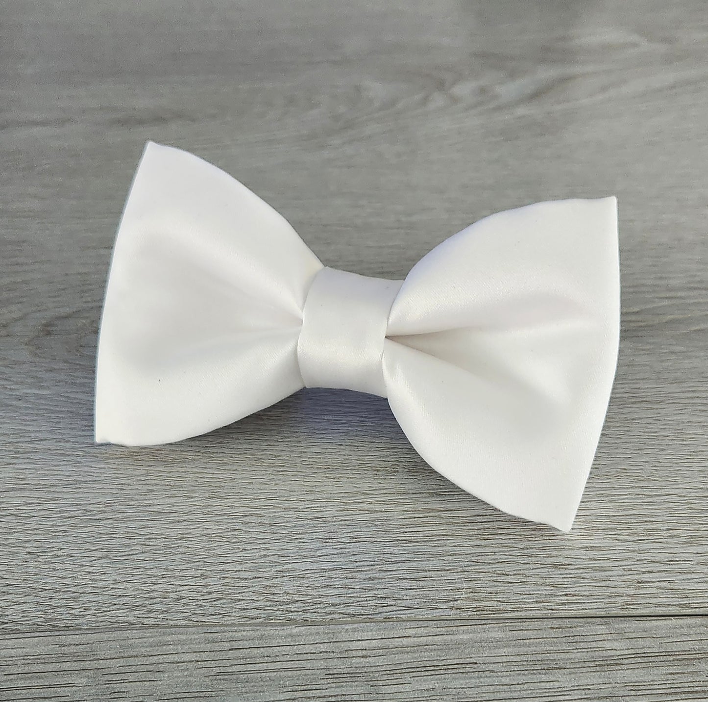 A white dog bow tie for the collar in matte satin fabric.