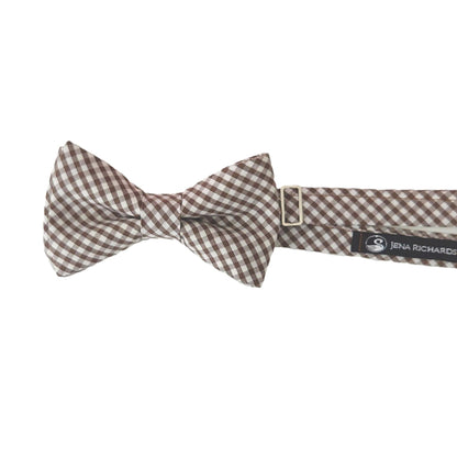 A chocolate brown gingham bow tie on a neck strap from Jena Richards.
