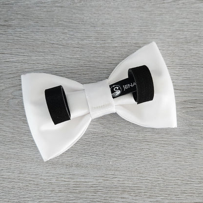 A white dog bow tie in matte satin fabric with Velcro tapes to attach to the collar.