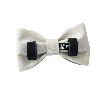 The back view of a sparkly silver dog bow tie with  Velcro tapes to attach to the collar.