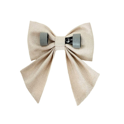 A back view of a sparkly pearl dog sailor bow with Velcro tapes to attach to the collar.