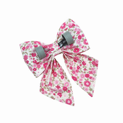 The back view of a dog sailor bow with hot pink flowers on a white background. Velcro tapes attach it to the collar.