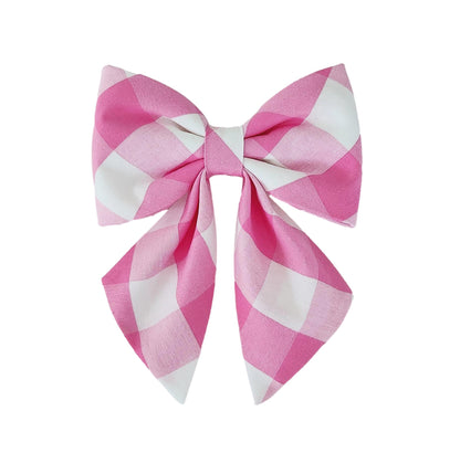 A dog collar bow for girls in pink and white buffalo check print for big and small dogs.