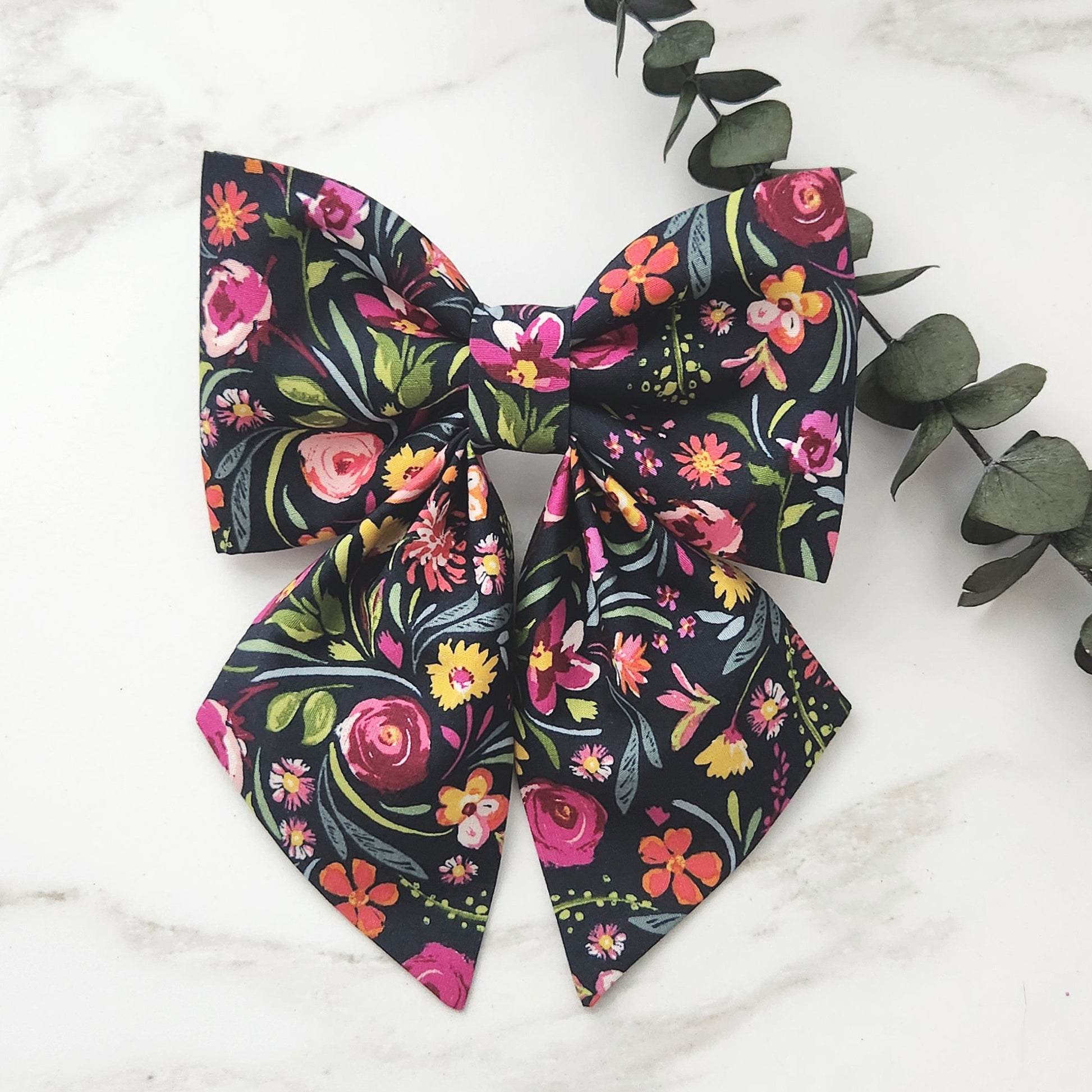 Dog sailor bows with colorful flowers on a black cotton background 