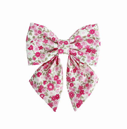 A bow for girl dogs for the collar in a hot pink floral print on a white background.