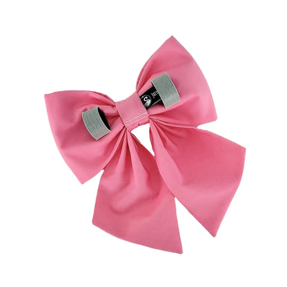 The back view of a bubblegum pink dog bow with Velcro tapes to attach to to the collar.