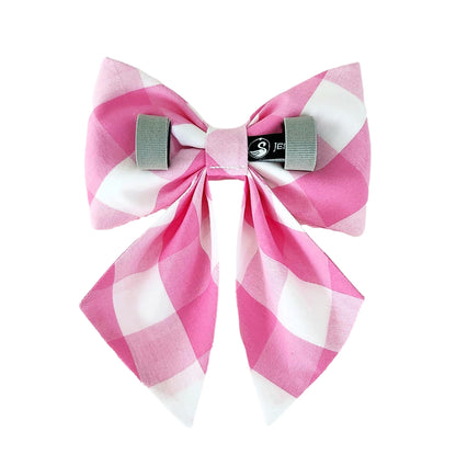 The back of a dog sailor bow in pink and white check print with Velcro tapes for attaching the bow to the collar.