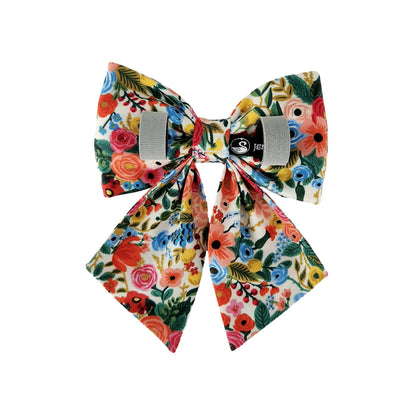 The back view of a colorful floral dog sailor bow with Velcro tapes to attach to the collar.