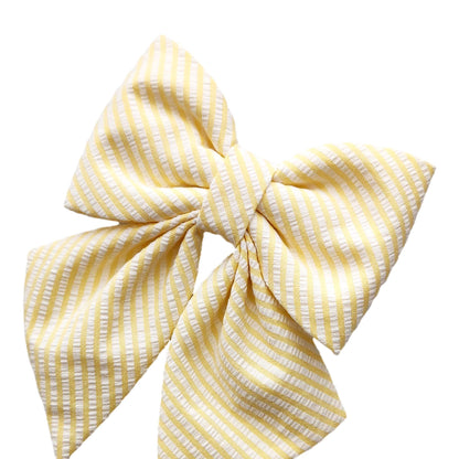 A close-up of a yellow seersucker collar bow for girl dogs.