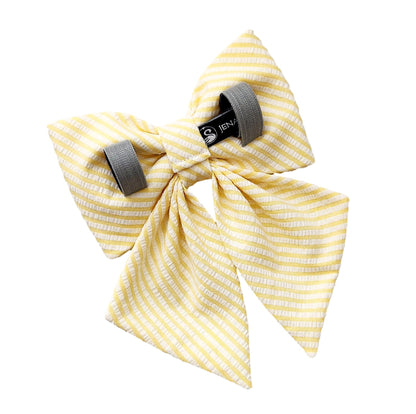 Back view of a yellow dog collar bow for girls in seersucker fabric with Velcro tapes that attach it to the collar. 