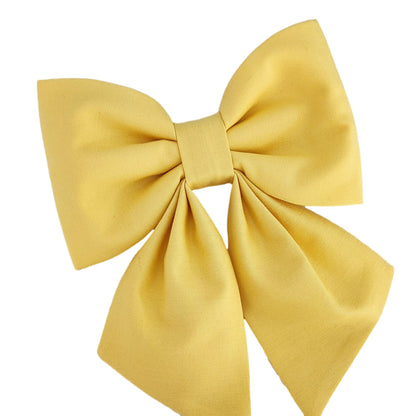 A closeup of a yellow dog collar bow for girls.