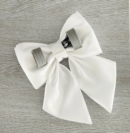 The back view of a white satin dog sailor bow with 2 Velcro tapes to attach to the collar.