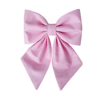 A pink glittery dog sailor bow that attaches to the collar for big and small dogs.